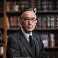 不良研究所首席研究员陈默的工作照，严肃而亲切的学者形象，书架背景